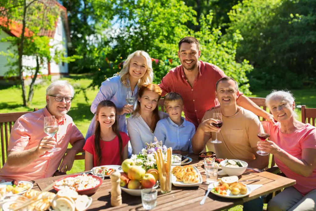 leisure holidays people concept happy family having festive dinner summer garden party celebrating