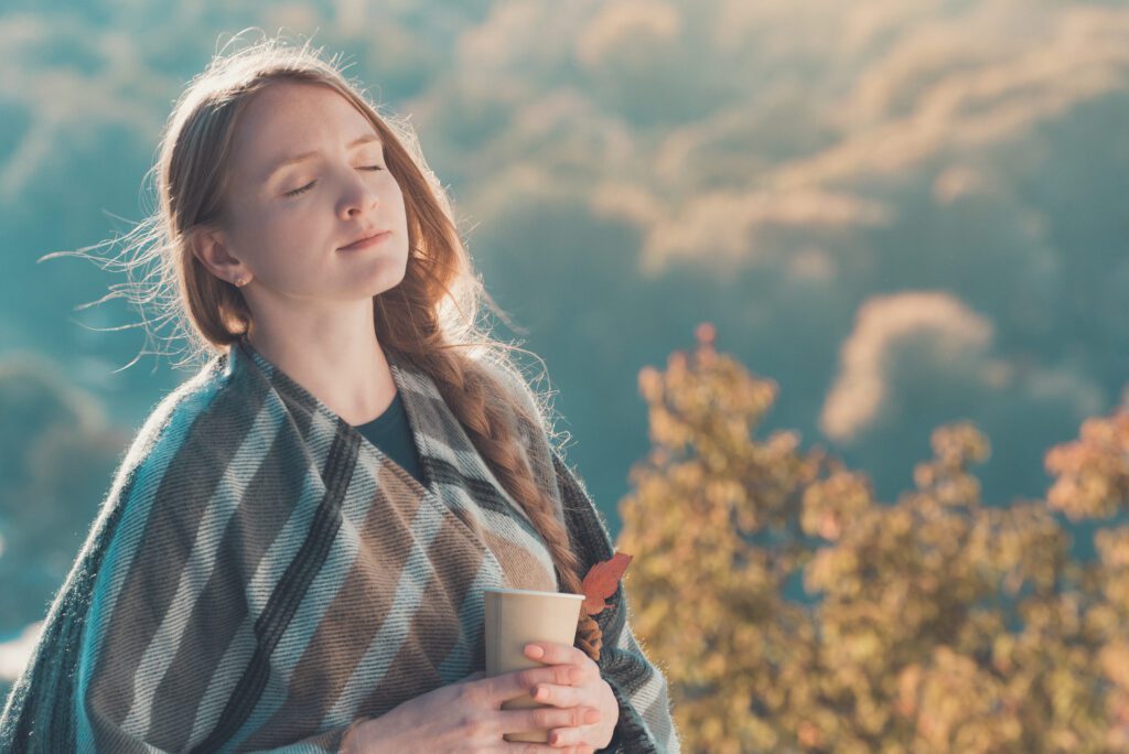 young woman with closed eyes enjoys air paper cup hands sunny day