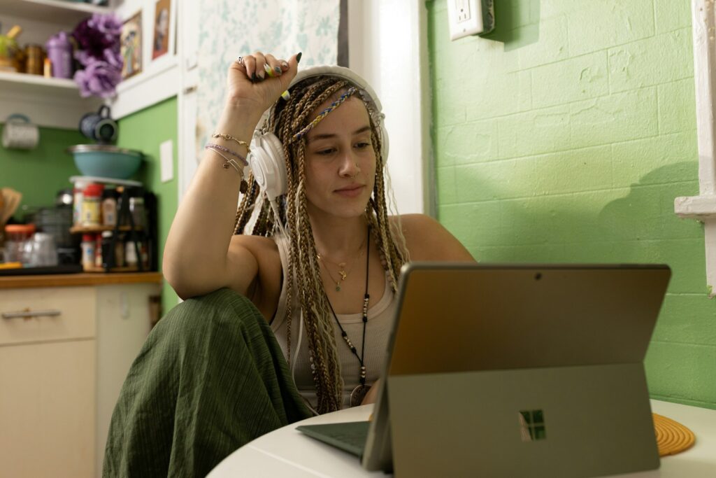 a woman with dreadlocks studing front of a laptop computer