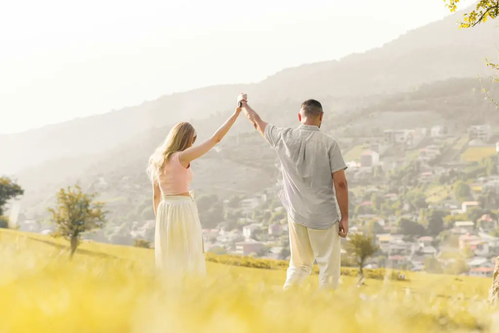 A man and a woman holding hands in a field