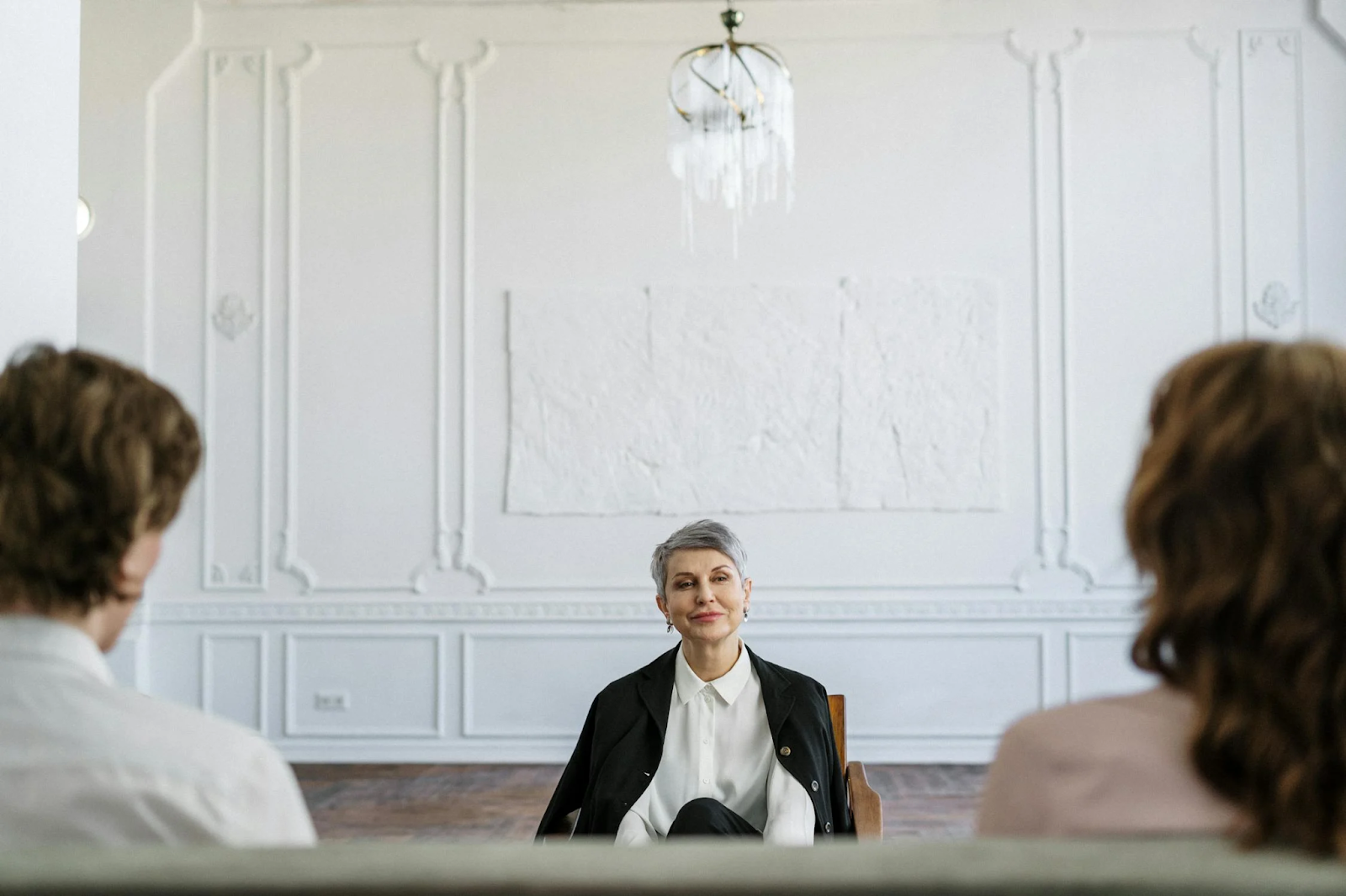 A short-haired woman talking to a couple going through divorce 