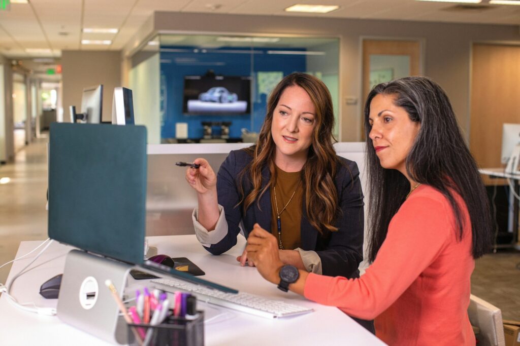 The Mental Strain of Leadership and How to Handle It Mindfully 2 two women sitting at a table looking at a computer screen