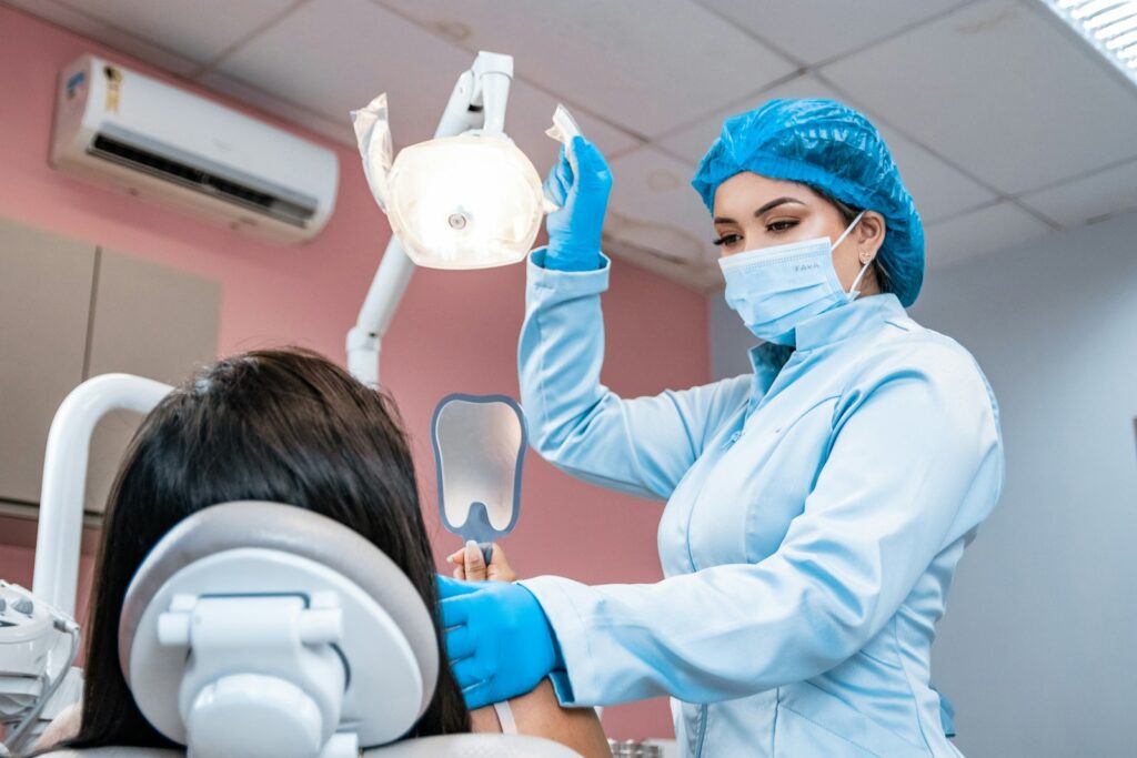 First Dental Visit? What to Expect and How to Manage Anxiety 2 a woman getting her teeth checked by a dentist