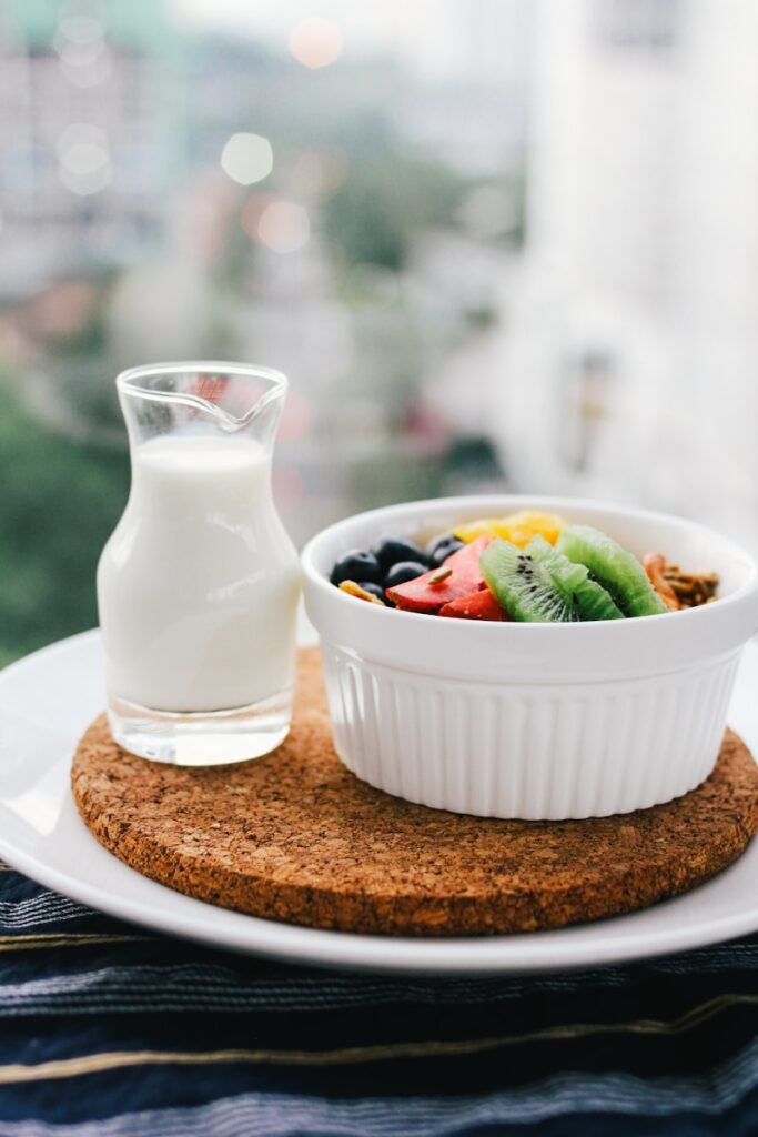 30 Days of Clean Eating Changed My Life: Here's How 2 fruit salad inside bowl beside glass of milk on brown board