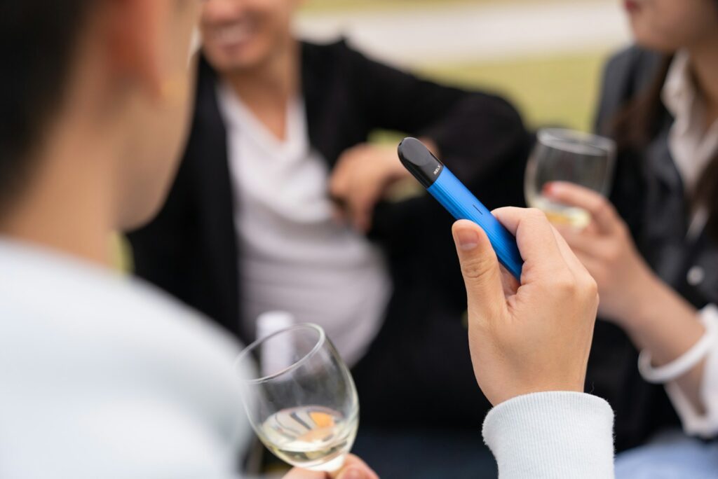 Why Cigarette-Styled Vapes Remain Popular Among Former Smokers 2 woman in white long sleeve shirt holding blue pen