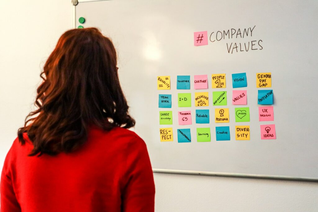 The Organizational Psychology Behind Companies That Adapt Well to Technological Change 2 a woman standing in front of a white board with sticky notes on it