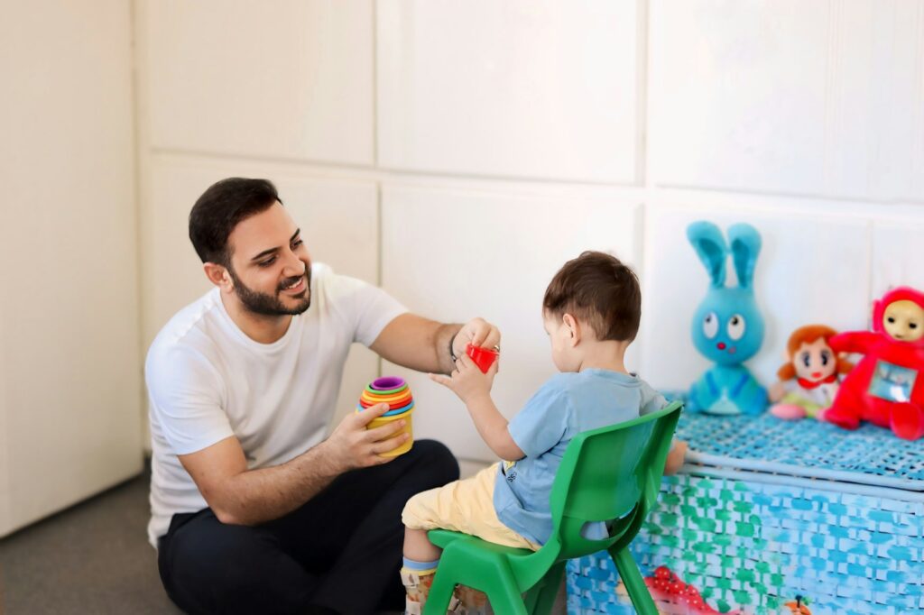 How Speech-Language Pathologists and Occupational Therapists Address Different Functional Needs 2 A man is playing with a child in a room